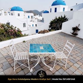 Modern ferforje işçiliğiyle üretilmiş beyaz sandalye ve geometrik desenli turkuaz çini masa detayı.