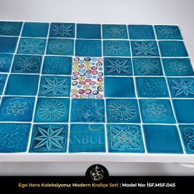 Masa tablası merkezindeki el yapımı nazar boncuğu figürlü seramik detay ve turkuaz çini motifleri.