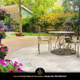 Geniş lüks villa bahçesinde taş patika, ortanca çiçekleri ve ahşap deck üzerinde yer alan iki adet Pera ferforje masa sandalye takımı